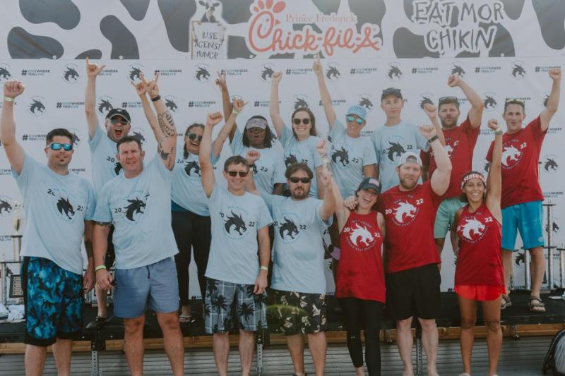 Team members of the 2022 Team North Beach for the End Hunger Dragon Boat Festival with their arms raised in celebration.