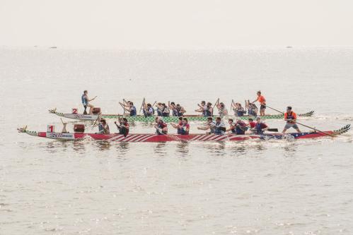 Dragon boats in the Chesapeake Bay with paddlers on board.